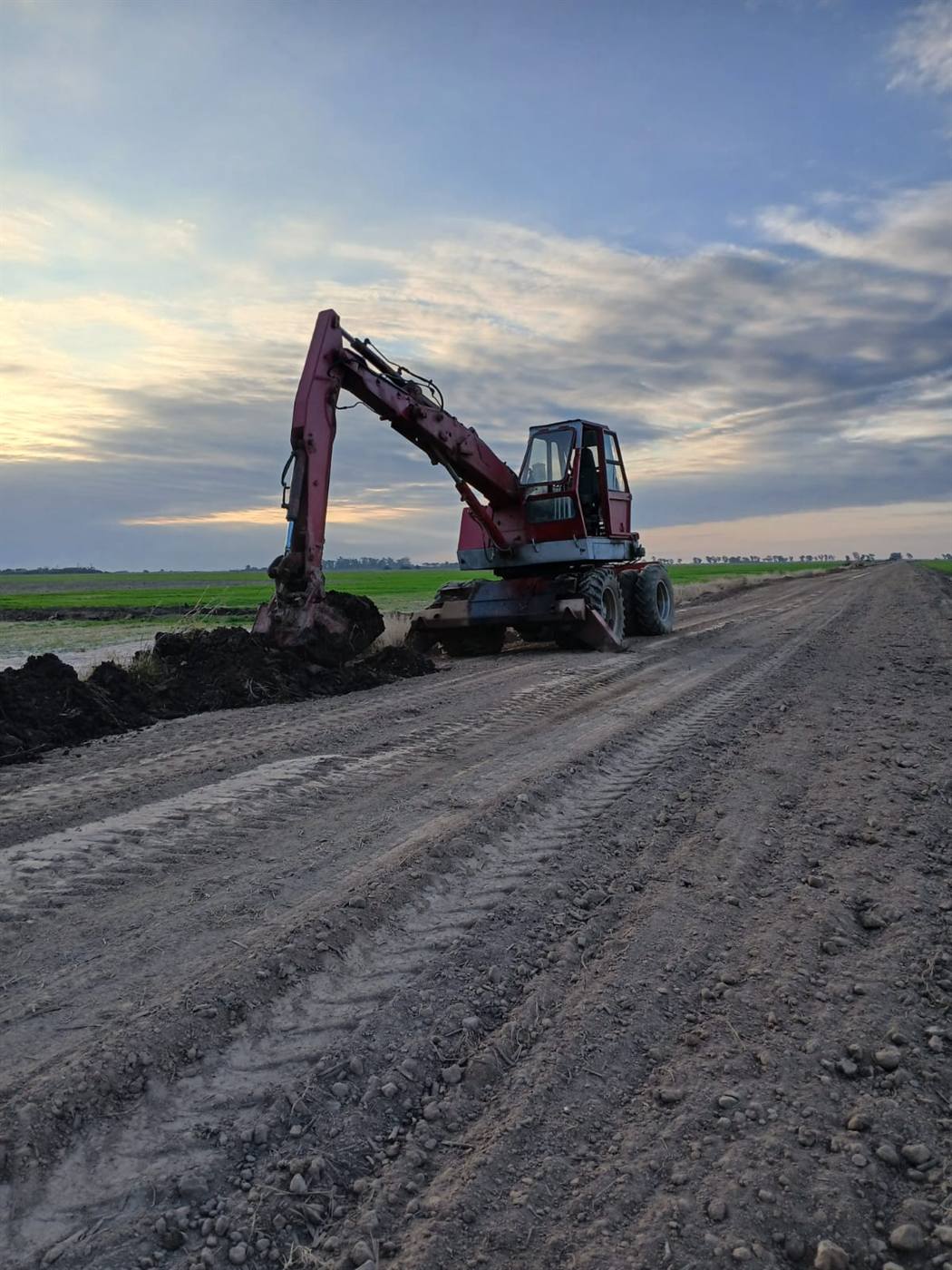 Excavadora de Hidra Dock abriendo una zanja al costado de un camino rural